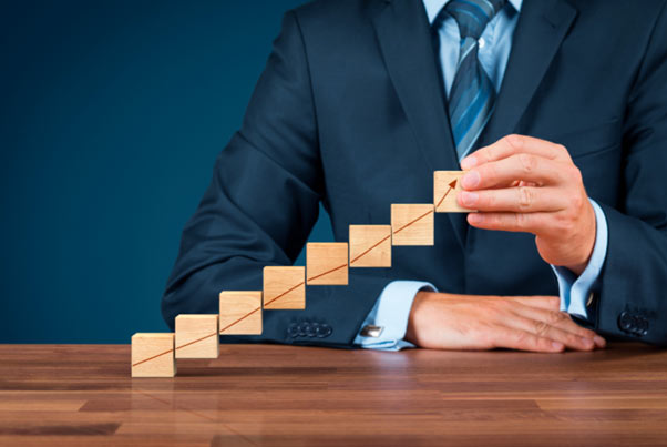 kostki trzymane w dłoniach obrazujące wzrost i rozwój firmy